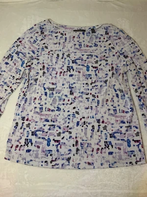 Mönstrad långärmad topp från Esprit - Säljer en långärmad topp från Esprit med abstrakt mönster i blått, lila, rosa och svart på vit botten. Toppen har rund halsringning och är gjord i mjuk bomullsmix. Perfekt för dig som gillar färg och unika prints!