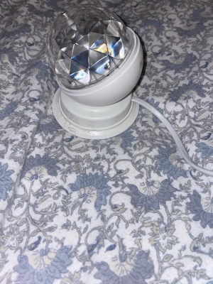 Vit discokula med sladd och strömbrytare - Elektrisk discokula i vit plast med genomskinlig, facettslipad kupol. Utrustad med vit sladd och enkel strömbrytare på sladden. Perfekt för att skapa partykänsla hemma eller på mindre event. Smidig att koppla in i vägguttag.