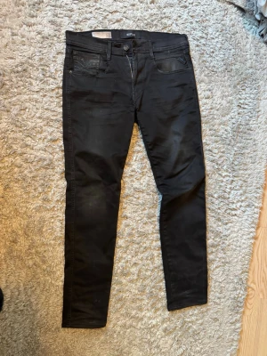 Svarta replay anbass - Säljer ett par svarta replay anbass jeans i storlek w31 l32. Slitet vid fickan och hål inuti men går att använda fickan ändå. 