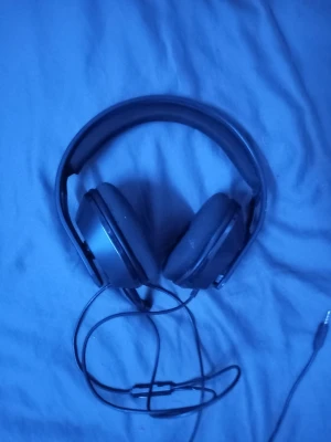 Svarta RIG gaminghörlurar med sladd - Säljer ett par svarta over-ear gaminghörlurar från RIG med kabel och 3,5mm-kontakt. Hörlurarna har en robust plastbåge och vadderade kåpor för extra komfort. Perfekta för gaming eller musiklyssning, med mikrofonarm på sidan.