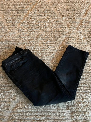 Dondup George jeans - Hej jag säljer ett par Dondup George jeans i nyaste årsmodellen i en riktigt snygg svart färg perfekt för dig som vill ha ett par kvalitetsjeans med grym passform. Nypris ≈3500kr, mitt pris 799kr. Skick: 9/10 Storlek: W33 Midja: 41cm Lår: 26cm Ytterlängd: 90cm. Innerlängd: 65cm. Skriv gärna om du vill ha fler bilder eller har frågor!