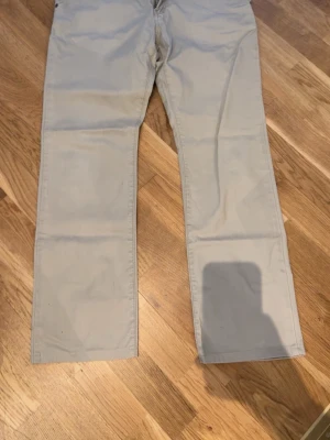 Armani Jeans - Ljusbeiga Armani jeans med rak passform och klassisk design. Byxorna har framfickor och bakfickor med enkel söm. Tillverkade i mjukt bomullstyg som ger en clean och avslappnad look. Perfekta för dig som gillar stilrena byxor.