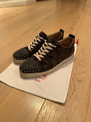 Christian Louboutin camo sneakers - Säljer med en tår i ögat. Ett par riktigt fina och efterfrågade camo loubs i storlek 43. Väldigt väldigt sparsamt använda, skick 9/10 nyss rengjorda. Kommer endast med dustbag, köpta på Trendsellers (kvitto finns). Kom dm för fler frågor osv!