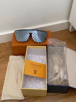 ZARA - Säljer ett par riktigt snygga Louis Vuitton solglasögon med spegelblått glas och klassiskt LV-monogram över hela linsen. Sköldpaddsliknande båge och medföljande originalfodral och box. Perfekt accessoar för dig som vill sticka ut.