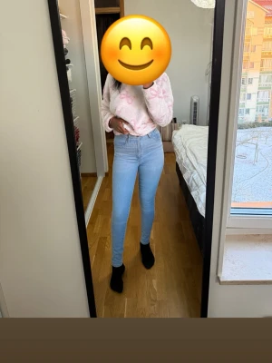 Ljusblå bootcut jeans med hög midja - Säljer ett par ljusblå jeans med bootcut-modell och hög midja. Jeansen har klassisk femficksdesign och är tillverkade i stretchigt denimtyg som sitter snyggt och bekvämt. Perfekta för dig som gillar en trendig och avslappnad stil.