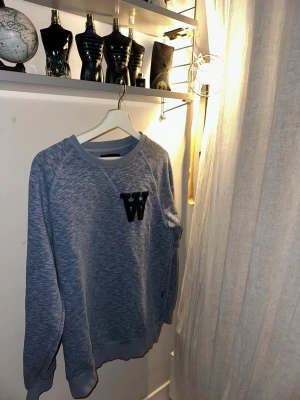 Ljus blå långärmad tröja från Wood Wood  - Wood wood sweater som tyvär inte passar i riktigt gott skick med den klassiska loggan Priset är inte hugget i sten.                       Storlek :MEDIUM                      