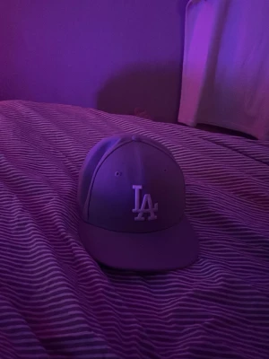 LA Dodgers keps från New Era - Snygg LA Dodgers keps från New Era med klassisk rak skärm och broderad LA-logga framtill. Kepsen är blå och har en stilren design som passar till streetwear. Tillverkad i bomullsmix och har en bekväm passform.