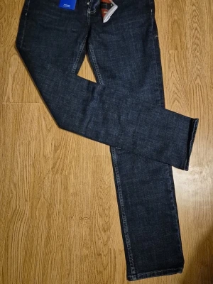 Jacob Cohën mörkblå jeans Bard - Snygga mörkblå jeans från Jacob Cohën, modell Bard. Tillverkade i Italien med naturlig indigo-färgning och exklusiva detaljer som färgglad näsduk i fickan och kontrastsömmar. Klassisk femficksmodell med knappgylf och unika broderier.