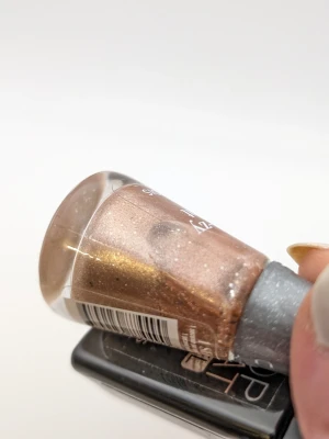 Bourjois Grey-zy Night nagellack rosa glittrigt 85% kvar - Nagellack från Bourjois i nyansen Grey-zy Night, en skimrande gråbrun färg med guldglitter. Flaskan har en smal, elegant form och locket är mörkgrått med glittereffekt. Perfekt för dig som gillar metallic och glans på naglarna.