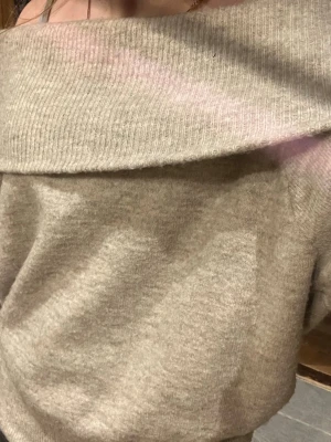 Beige off shoulder stickad tröja - Säljer en beige stickad tröja med bred off shoulder-krage. Tröjan har en avslappnad passform och långa ärmar med ribbade muddar. Perfekt för dig som gillar en trendig och mysig stil. Materialet känns mjukt och skönt mot huden. Köpte på Vinted ifjol och har knappt använt den💕