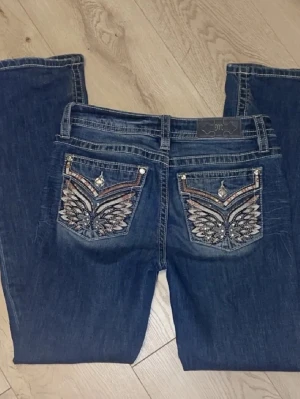 Miss Me jeans - Säljer ett par bootcut jeans från Miss Me med snygga broderade bakfickor och blingdetaljer. Perfekta för dig som vill sticka ut med detaljer och unik design. Skriv för fler bilder🤍