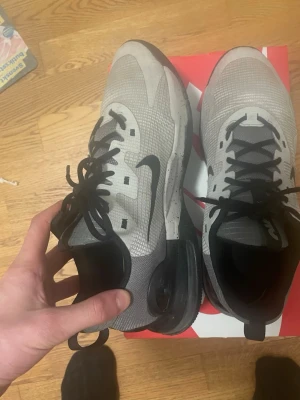Nike Skor storlek 47 oanvända, box tillkommer - Nike skor oanvända sneakers i grått med svarta detaljer och svart sula. Ovandelen är i meshmaterial för bra andningsförmåga och skon har en tydlig Air Max-dämpning i hälen. Klassisk Nike-logga på sidan och svart snörning. Perfekta för en sportig och stilren look. Jag säljer dem för de passar inte mig.