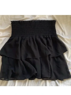 Svart kjol  - Volangkjol från Kappahls barnavdelning, storlek 170 men passar typ xs/s. Passar bra på sommaren eller till strumpbyxor. Använd mycket men ändå bra skick. Skriv för fler bilder 🩷