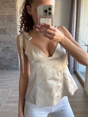 Beige omlott topp med knytband - Snygg beige topp med omlott-design och knytband på axlarna. Ifrån gina tricot. Använd 1 gång 💕