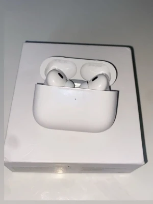 Apple AirPods Pro 2 trådlösa hörlurar - Säljer ett par vita Apple AirPods Pro 2 med laddningsetui. De är trådlösa in-ear-hörlurar med stilren design och silikonproppar för bra passform. Perfekta för musik, samtal och träning. Kommer i originalförpackning.