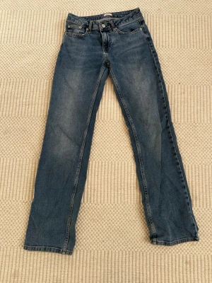 Blå raka jeans från Nelly - Klassiska blå jeans från Nelly med rak passform. Jeansen har en snygg tvätt perfekta till en avslappnad stil och tillverkade i bomullsdenim. Är inte helt säker på storlek men tror xs🥰