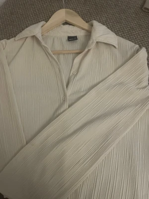 Beige plisserad skjorta  - Stilren beige skjorta från Gina använt sparsamt 