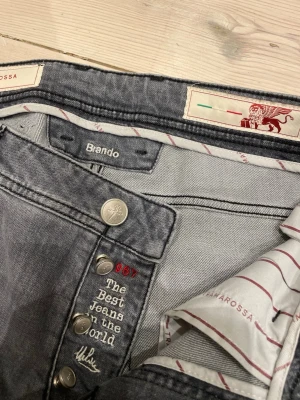 Tramarossa Brando jeans herr - Snygga grå jeans från tramrossa, modell Brando. Nypris ca. 5000kr men säljer nu dessa för under tusenlappen! Klassisk femficksdesign med raka ben och normal passform. Jeansen har en diskret tvätt och röda detaljer vid linningen. Perfekta till en avslappnad stil och tillverkade i mjukt bomullsmaterial.