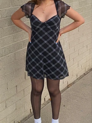 Grunge mesh klänning - Snygg svart kortklänning med vitt rutmönster och transparenta meshärmar. Den är från H&M divided