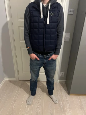 Mörkblå replay väst  - Tjenaret! Säljer nu denna tvär feta väst från replay i storlek M. Mycket bra skick med inga defekter, killen på bilden är ca 185 och den är lite för liten. Hör av er vid minsta fundering! MVH premium fashion 