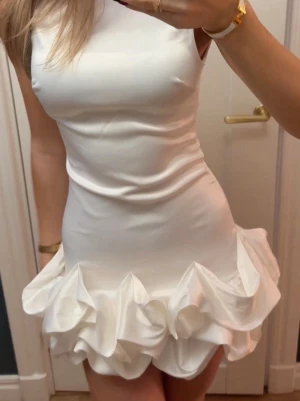 BUDGIVNING. Högsta bud 650kr. Vit kort klänning med volang - BUDGIVNING. Högsta bud just nu 650kr. Direktköp accepteras inte! Intressekonflikt på min supersnygga vita korta klänning då den är lite för kort för mig. Bara provad. 