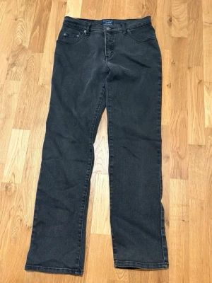 Svarta raka jeans från Wrangler - Snygga svarta jeans från Wrangler med rak passform och klassisk femficksdesign. Jeansen har normal midja och är tillverkade i ett slitstarkt denimtyg. Perfekta för dig som gillar en tidlös och enkel stil.