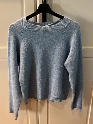 Ljusblå stickad tröja Vero Moda - Mysig ljusblå stickad tröja från Vero Moda med rund halsring. Perfekt för lager-på-lager och enkel att matcha med jeans eller kjol. Den är nopprig