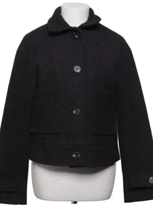 Svart kappa med stora knappar - Stilren svart jacka i ull med rak passform och stora knappar framtill. Jackan har två stora fickor och klassisk krage. Perfekt för kyliga dagar och enkel att matcha med olika outfits. Från lager 157, aldrig använd!