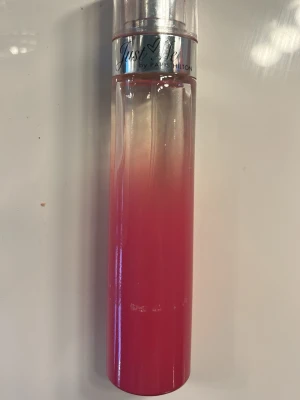 Just Me parfym av Paris Hilton - Just Me parfym från Paris Hilton i en snygg cylinderformad flaska med rosa till transparent färgövergång och silvrig detalj vid korken. Flaskan är gjord av glas och har en modern, ungdomlig design.