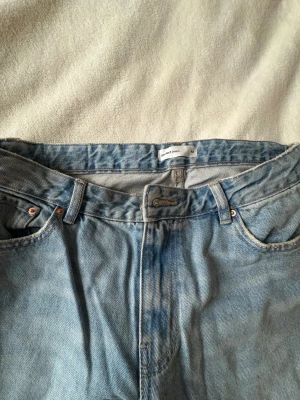 Ljusblå raka jeans från Gina tricot  - Säljer ett par ljusblå jeans från ginatricot med klassisk femficksmodell och raka ben. Jeansen har normal midja, bälteshällor och är gjorda i 100% bomull för en skön vintagekänsla. Endast testade i storlek 42.