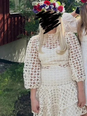 Vit spetsklänning med volang - Superfin vit kortklänning i spets med volangdetaljer och puffiga trekvartsärmar. Klänningen har rund halsringning och markerad midja, perfekt för somriga tillfällen. Passar perfekt till studenten. Storlek M men passar S-M 