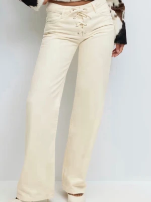 Jeans med snören - Jätte snygga raka/utsvängda jeans från Gina tricot, fick de i julklapp och har aldrig använt men lappen är avtagen, det är cremefärgade inte beiga. Skulle säga att det är midwaist men man kan ha dom som lowwaist också