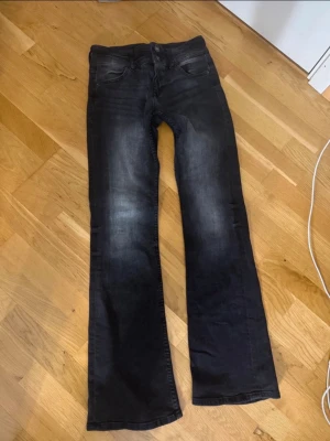 Svarta bootcut jeans med slitningar - Säljer ett par svarta bootcut jeans tvättade detaljer på låren. 