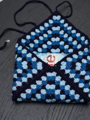 Virkad booksleeve  - Virkad booksleeve, passar bland annat häftade böcker (storpocket). Boken på bilden är 13,5x21cm.  Virkad i akrylgarn.  Färger kan variera beroende på skärminställningar.  Obs boken ingår inte.