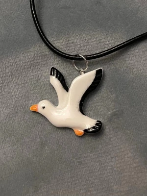 Mås halsband fiskmås  - 10% av detta köpet skänker jag till Shimmer of Hope Sanctuary, som hjälper måsar i Storbritannien.   Så fint halsband med en berlock i form av en mås! Berlocken är ca 3 x 2,5 cm. Trädd på svart tråd, justerbar 40-45 cm. Visa din kärlek till dessa underbara fåglar med detta halsbandet!  