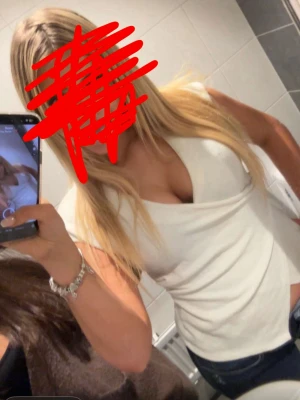 Vit omlottopp med v-ringning - Säljer en snygg vit omlottopp med v-ringning och korta ärmar. Toppen har en markerad omlott-detalj med dekorativ knapp i sidan och är figurnära i modellen. Perfekt att styla med jeans eller kjol för en trendig look.