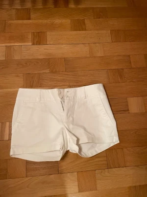 Vita shorts från Lacoste - Snygga vita shorts från Lacoste med klassisk design med fickor fram och bak. Perfekta för varma dagar och enkel att matcha med olika toppar ☀️