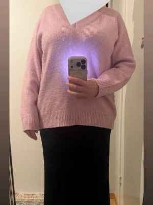 Ljusrosa stickad tröja  - Mysig ljusrosa stickad tröja.Tröjan har en klassisk rak passform, ribbade muddar vid ärmslut och nederkant samt lång ärm. Perfekt att matcha med jeans eller kjol för en chill look.