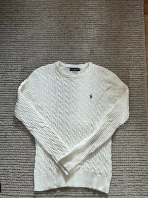 Kabelstickad telja från ralph lauren - Skön Polo Ralph Lauren vit kabelstickad tröja. Skick 9/10, inga defekter Medium, skön passform Skriv vid funderingar!