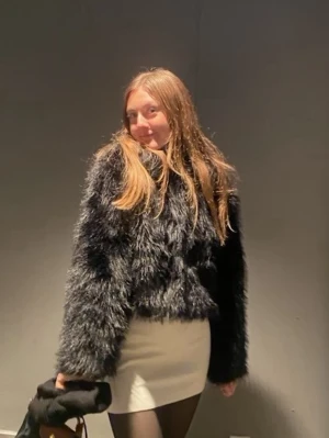 Svart fluffig pälsjacka - Säljer en svart pälsjacka med fluffig och mjuk känsla. Jackan har en kortare, boxig passform och långa ärmar. Super skön och varm när det är kallare ute. Har så många pälsjackor så säljer därav!💗 Den är i storlek L men den är verkligen mer storlek S eftersom den skulle vara croppad.