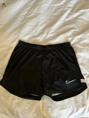 Svarta träningsshorts från Nike - Säljer ett par svarta träningsshorts/fotbollsshorts från Nike. De är i strl M men jag har vanligt vis S i storlek då sitter de inte jättetajt💗