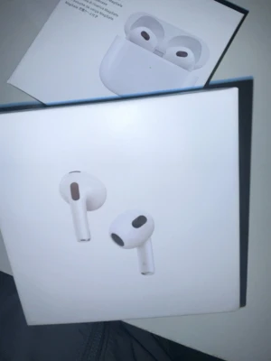 Apple AirPods 3  - Säljer ett par vita Apple AirPods 3 med MagSafe-laddningsetui. Trådlösa in-ear-hörlurar med stilren design och smidigt laddningsfodral. Perfekta för musik, samtal och träning. Grym ljudkvalitet och enkel anslutning till iPhone och andra Apple-enheter.