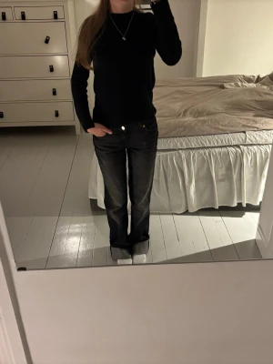 Svart stickad tröja med rund hals - Säljer en enkel och stilren svart stickad tröja i kashmir med rund hals och långa ärmar. Tröjan har en smal passform och är perfekt att matcha med jeans eller kjol. Materialet ser mjukt och bekvämt ut, perfekt för kyligare dagar.