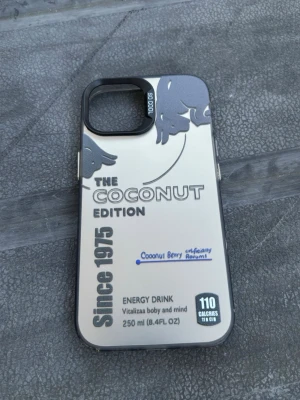 Red bull iphone 15Coconut Edition mobilskal silver - Till iPhone 15. Unikt mobilskal i silver med tryck inspirerat av energidryck, texten 'The Coconut Edition' och detaljer i svart och blått. Skalets design har kokosnötmotiv och markerad kameralins. Passar dig som vill sticka ut med en cool och modern look.