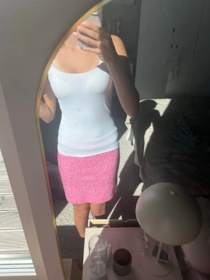 Rosa stickad kortkjol - Superfin rosa stickad kjol med rak passform och kort längd. Kjolen har en enkel design utan synliga detaljer och är perfekt för dig som gillar en färgglad och trendig look. Passar perfekt till både linne och t-shirt för en avslappnad stil.