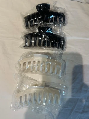 4-pack hårklämmor nya  - Helt nya hårklämmor som jag köpt från Fyndiq. Har öppnat en av klämmorna från påsen (se bild). Aldrig använd. Utan alla är helt nya. Nypris 112kr. Två vita och två svarta klämmor. Dom är mjukare i materialet än ”vanliga” hårklämmor. 🤍