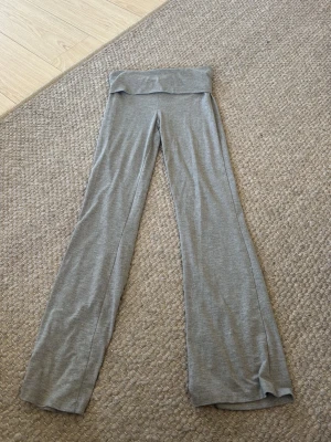 Grå yoga pants - Säljer ett par grå yoga pants. De är tillverkade i ett mjukt och stretchigt material som sitter skönt och följsamt. Perfekta för dig som gillar en avslappnad och trendig look.
