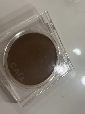 CAIA Soft Melt Bronzing Balm San Jose - Bronzer från CAIA i nyansen San Jose. Kommer i en rund, genomskinlig plastförpackning med lock. Färgen är en varm, mediumbrun ton som ger ett naturligt solkysst resultat. Krämig formula som smälter in i huden för en fräsch look.