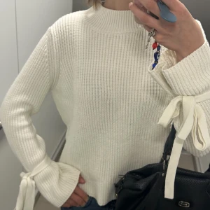 Stickad tröja med rosett - Säljer denna jättefina stickade tröja från Gina tricot med rosetter runt handlederna! Supersöt, säljer pga får ingen användning av den (kan ladda upp flera bilder om det önskas)