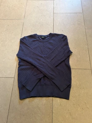 Mörkblå stickad tröja KappAhl - Säljer en mörkblå stickad tröja från KappAhl med diskret rutmönster. Tröjan har rund halsringning, långa ärmar och ribbade muddar vid ärmslut och nederkant. Helt ny oanvänd❤️